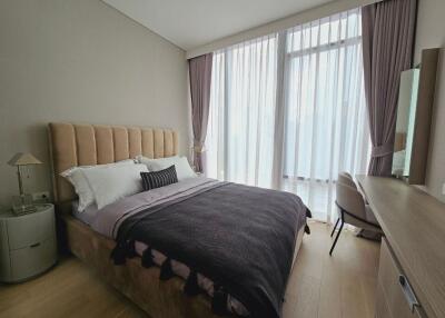 Modern bedroom with a large window and elegant furnishings