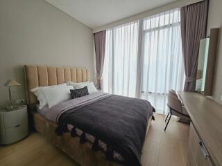 Modern bedroom with a large window and elegant furnishings