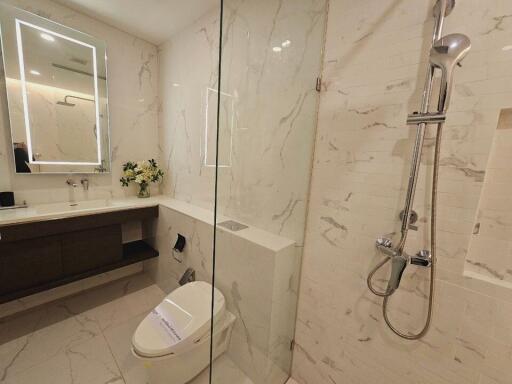 Modern bathroom with marble walls, shower and toilet