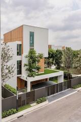 Modern three-story building with a rooftop garden and wooden accents