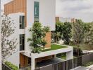 Modern three-story building with a rooftop garden and wooden accents