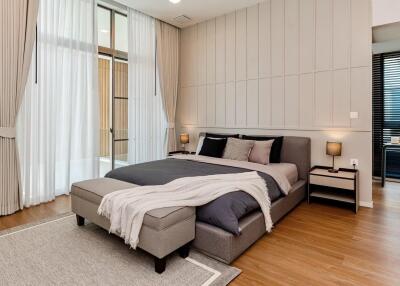 Modern bedroom with a large bed, bedside tables, and curtains