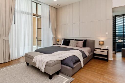 Modern bedroom with a large bed, bedside tables, and curtains