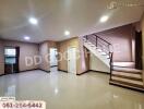 Spacious living room with staircase and glossy tiled floor