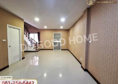 Spacious living room with staircase and large tiled floor