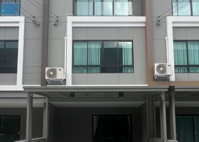 Modern townhouse exterior with balconies and gated entrance