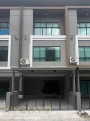 Modern townhouse exterior with balconies and gated entrance