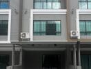 Modern townhouse exterior with balconies and gated entrance