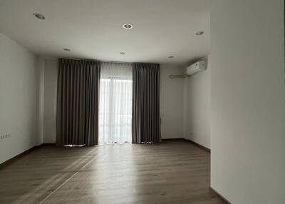 Spacious and empty living room with large windows and curtains