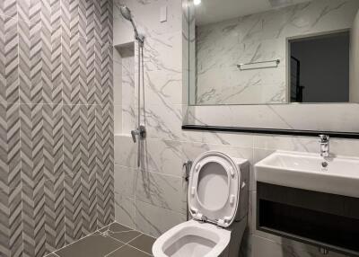 Modern bathroom with tiled shower and large mirror