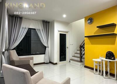 Modern living room with yellow accent wall and staircase