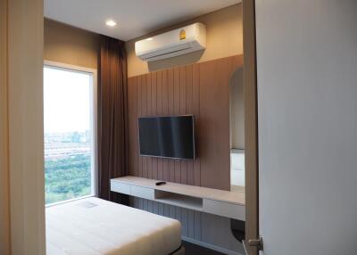 Modern bedroom with wall-mounted TV and scenic window view