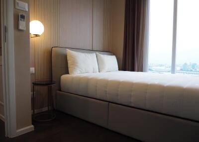 Modern bedroom with a large bed and natural light.