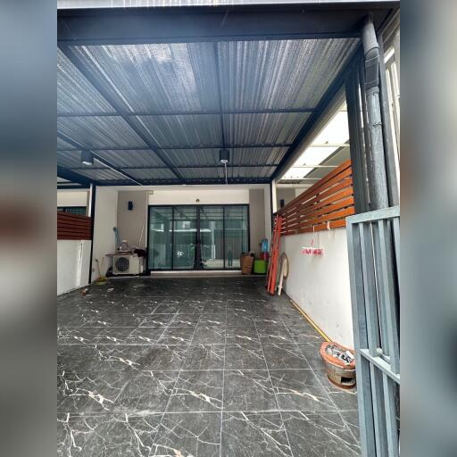 Covered garage with marble flooring and large sliding doors