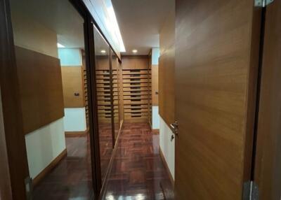 Modern hallway with wooden doors and reflective surfaces