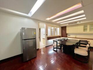 Spacious dining area with table and chairs, adjacent to a kitchen