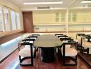 Modern dining area with a large table and chairs, mirrored wall, and ample cabinet space.