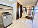 Laundry room with modern washing machine and storage compartments