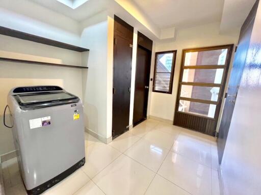 Laundry room with modern washing machine and storage compartments