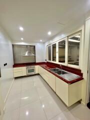 Modern kitchen with red countertops and ample storage space