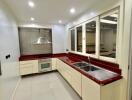 Modern kitchen with red countertops and ample storage space