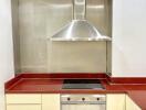 Modern kitchen with stainless steel hood, electric stove, and oven