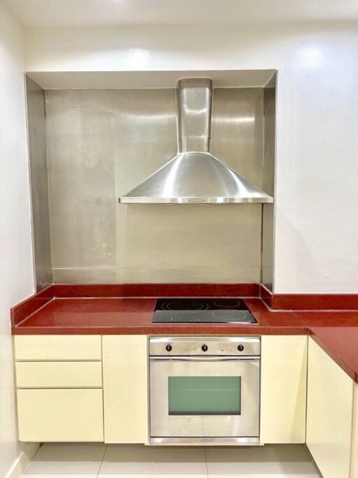 Modern kitchen with stainless steel hood, electric stove, and oven