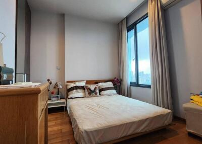 Bedroom with large window and wooden furniture