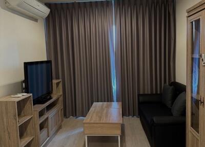 Living room with modern furniture, TV unit, and large curtains