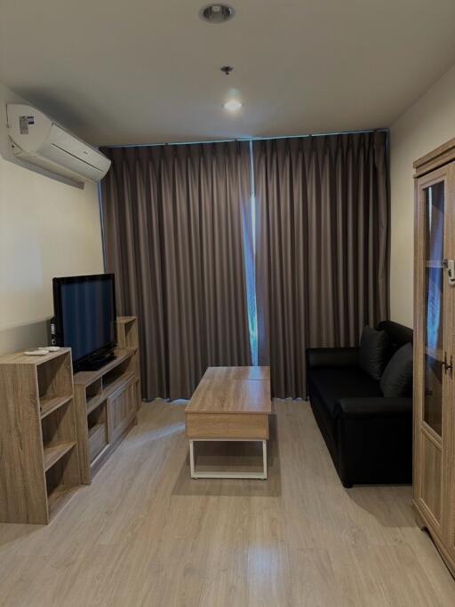 Living room with modern furniture, TV unit, and large curtains