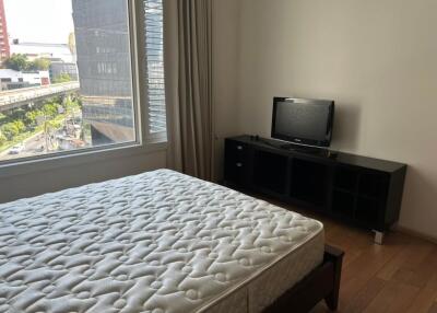 Bedroom with a bed, large window, and TV stand