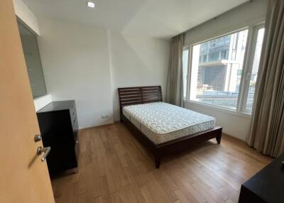 Bedroom with a large window and wooden bed frame