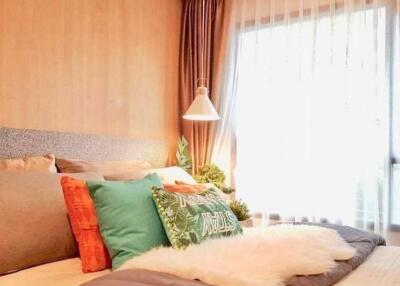 Cozy bedroom with decorative pillows and bedside lamp