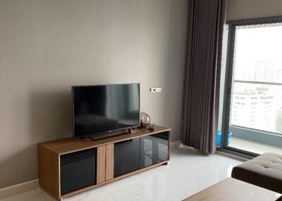 Living room with modern decor, TV stand, and city view