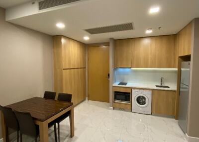 Modern kitchen and dining area with wooden cabinets, dining table, and integrated appliances