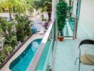 Balcony overlooking pool with lush greenery