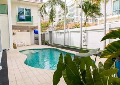 Outdoor swimming pool in a residential property with surrounding greenery and patio area