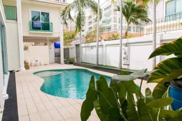 Outdoor swimming pool in a residential property with surrounding greenery and patio area