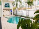 Outdoor swimming pool in a residential property with surrounding greenery and patio area