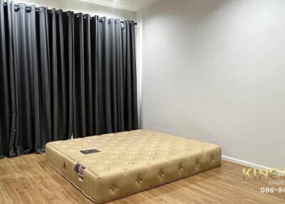 Bedroom with a mattress on the floor and black curtains