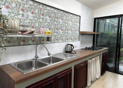 Kitchen with floral backsplash and dual sink