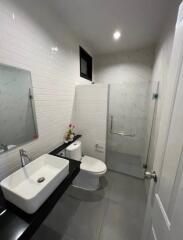 Modern bathroom with glass shower, sink, toilet, and wall mirror