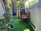 narrow garden with artificial grass and wooden bench