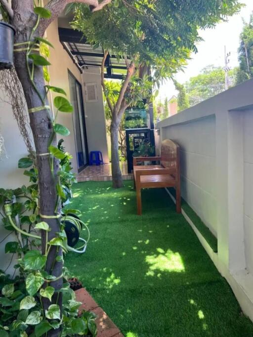 narrow garden with artificial grass and wooden bench