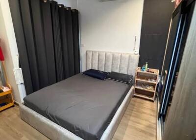 Modern bedroom with bed, black curtains, and a mini-split air conditioner