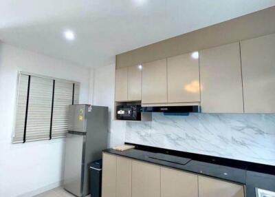 Modern kitchen with beige cabinets and marble backsplash