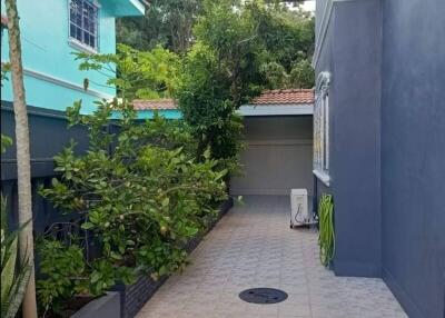 Exterior view of a building with a tiled pathway and lush greenery