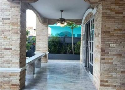 Covered patio with stone walls and tiled floor