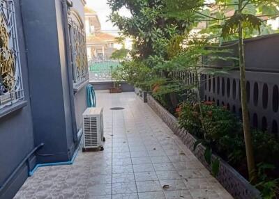 Outdoor corridor with tiled floor, plants, and air conditioning unit