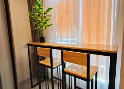 Compact dining area with high table and chairs next to a window